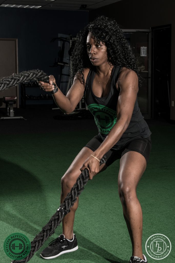 Member working the battle ropes on the turf